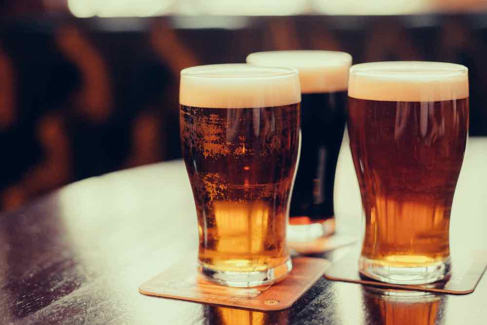 Glasses of lager on a table. Rakau hops are used to make lagers, IPAs, and other lighter color beers.