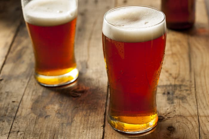 Two pint glasses of amber beer.