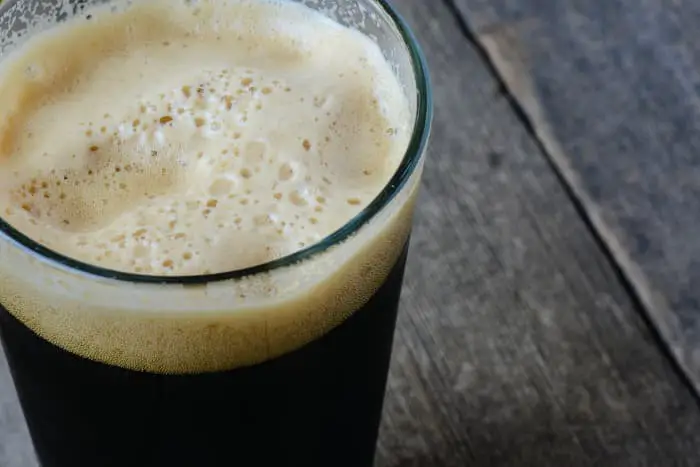 A pint glass of dark porter or stout beer.