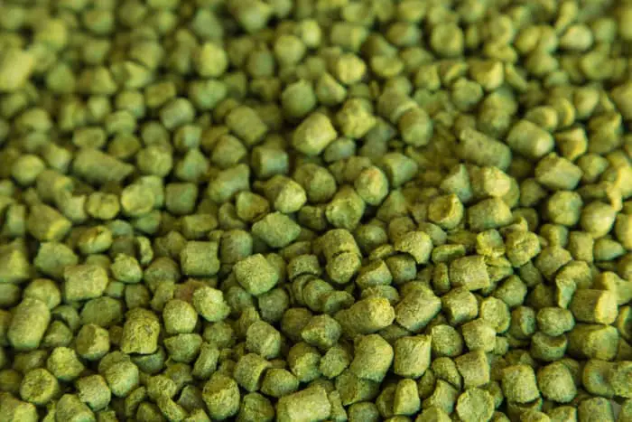 Closeup of greenish-brown dried hops pellets.