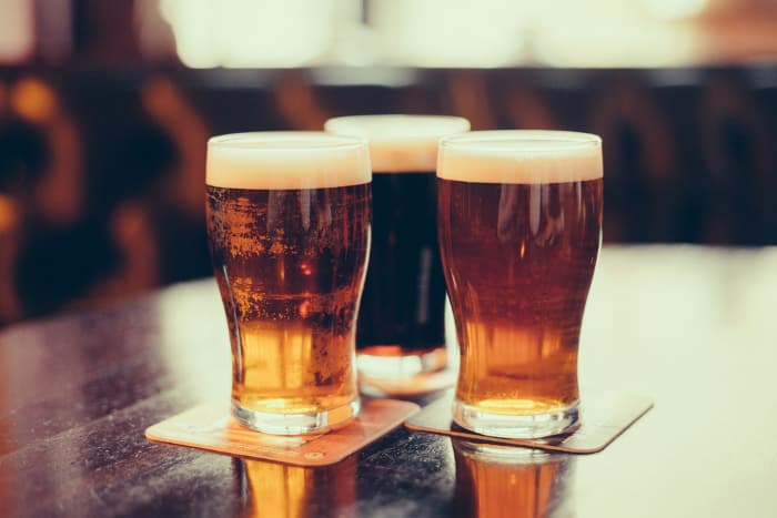 Pint glasses of beer on a pub or bar table.