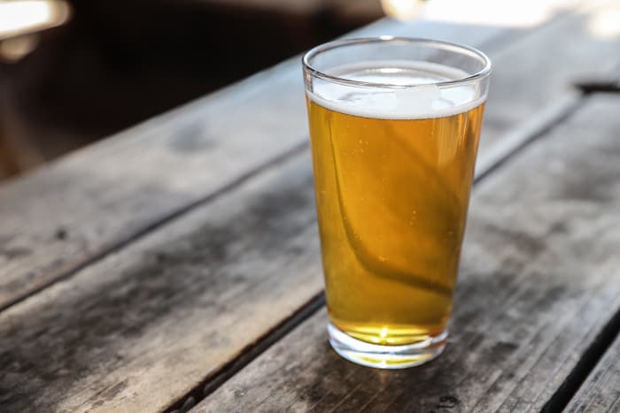 A pint glass of pale golden colored beer.