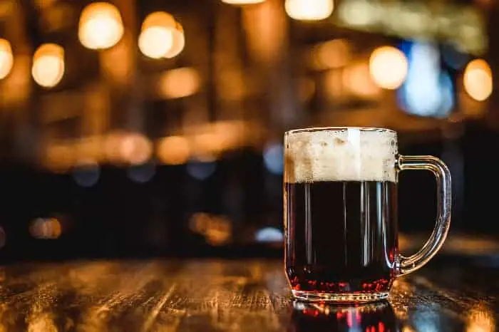 Mug of dark beer on a bar or pub table.