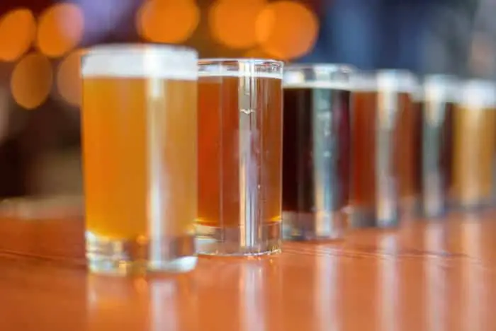 Row of glasses of different colored beer.