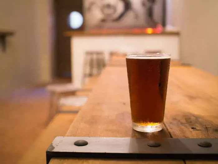 A pint glass of ale on a table.