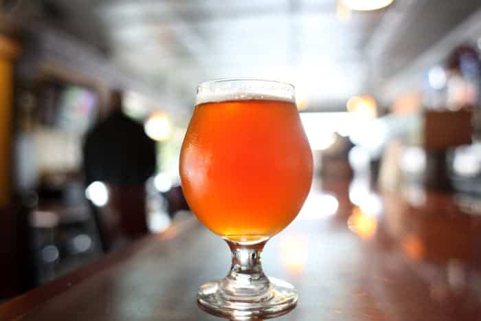 Goblet of amber-colored beer on a bar.