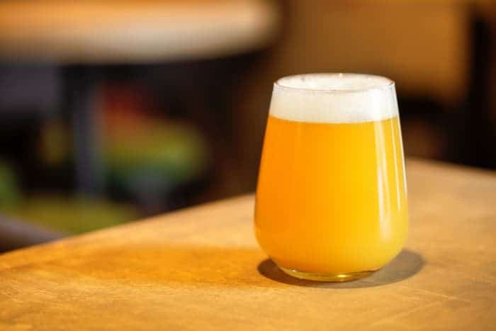 A glass of hazy IPA, also known as New England IPA beer.