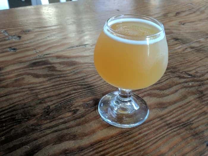 Goblet of hazy wheat beer on table. Idaho 7 hops are used to make wheat beers, pale ales, and IPAs.
