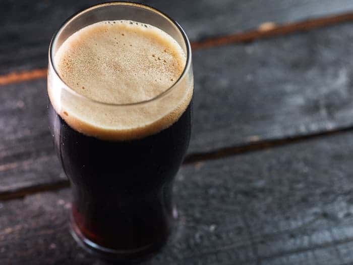 Glass of porter beer on a pub table.