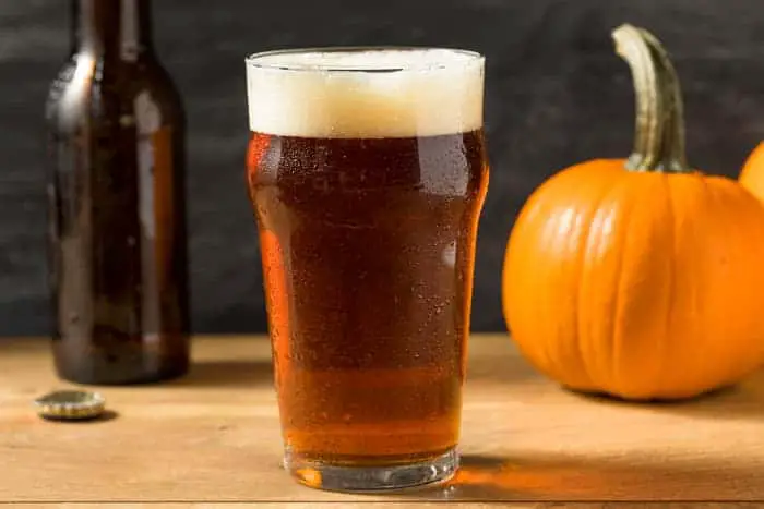 A pint glass of amber-colored pumpkin ale.