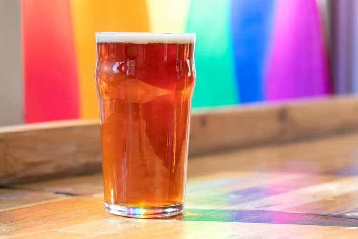 A pint glass of amber colored beer.