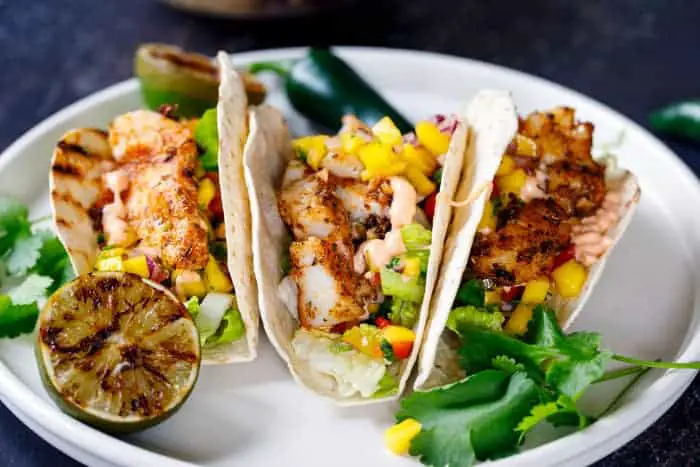 A plate of fish tacos with mango salsa.