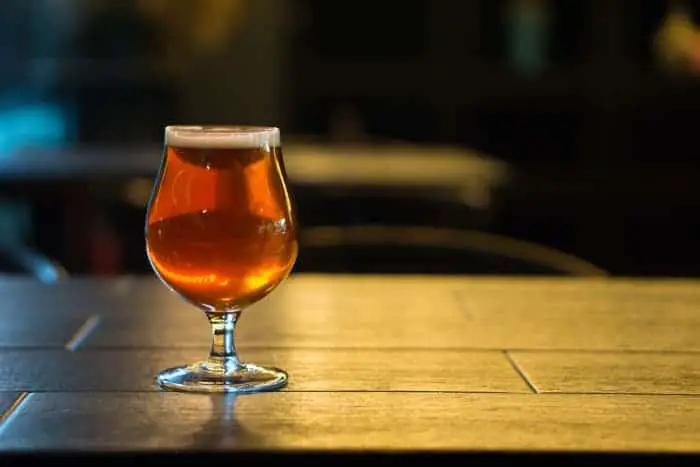 A goblet of amber colored beer, similar to honey beer.