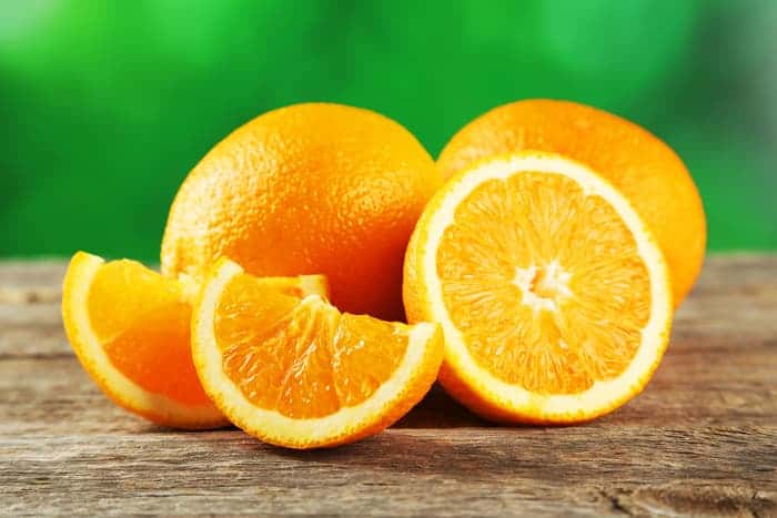 Group of oranges, one cut into wedges.