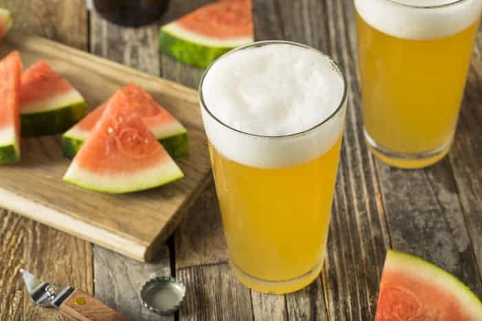 Pint glasses of watermelon fruit beer.