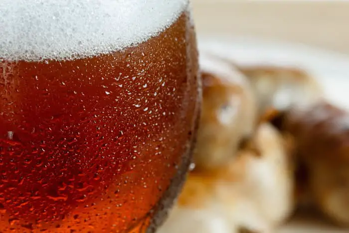 Closeup of a goblet of reddish-colored beer.