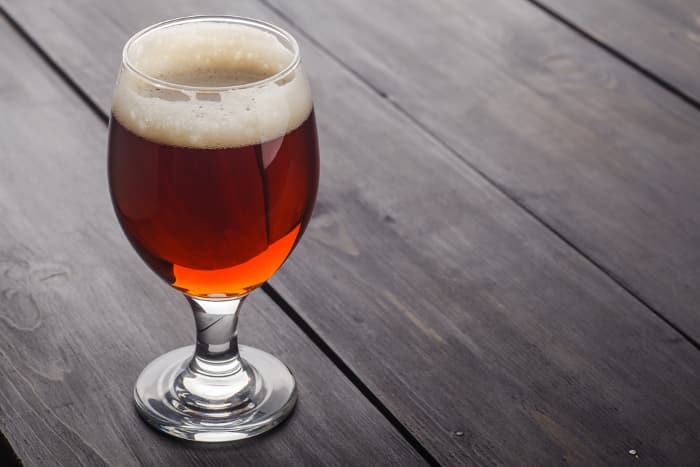 A goblet of reddish-colored beer.