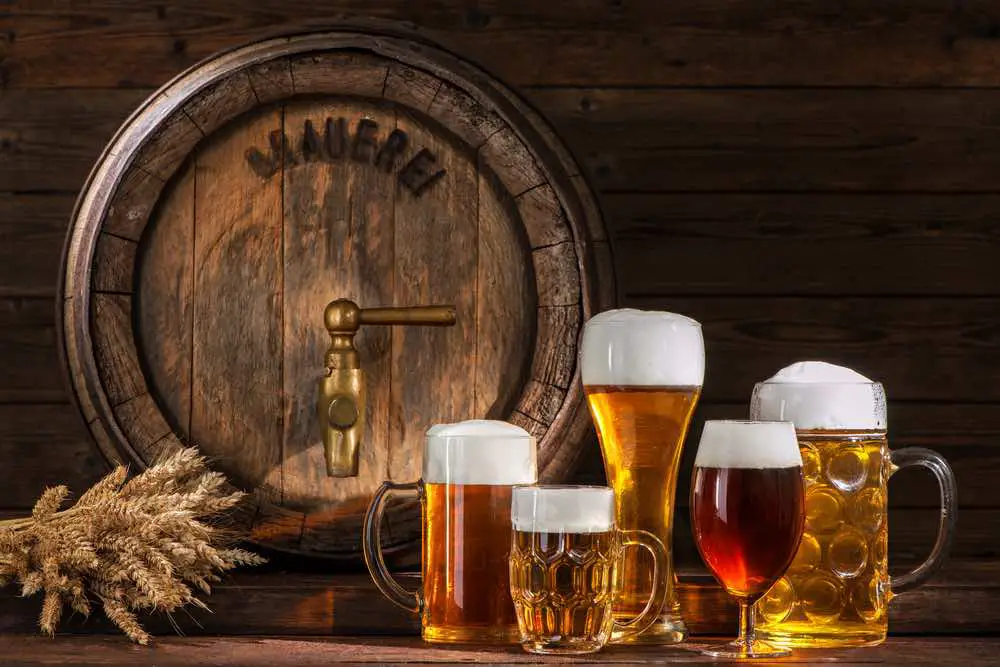 beer glasses next to a barrel